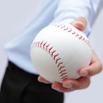 homme tendant une balle de baseball